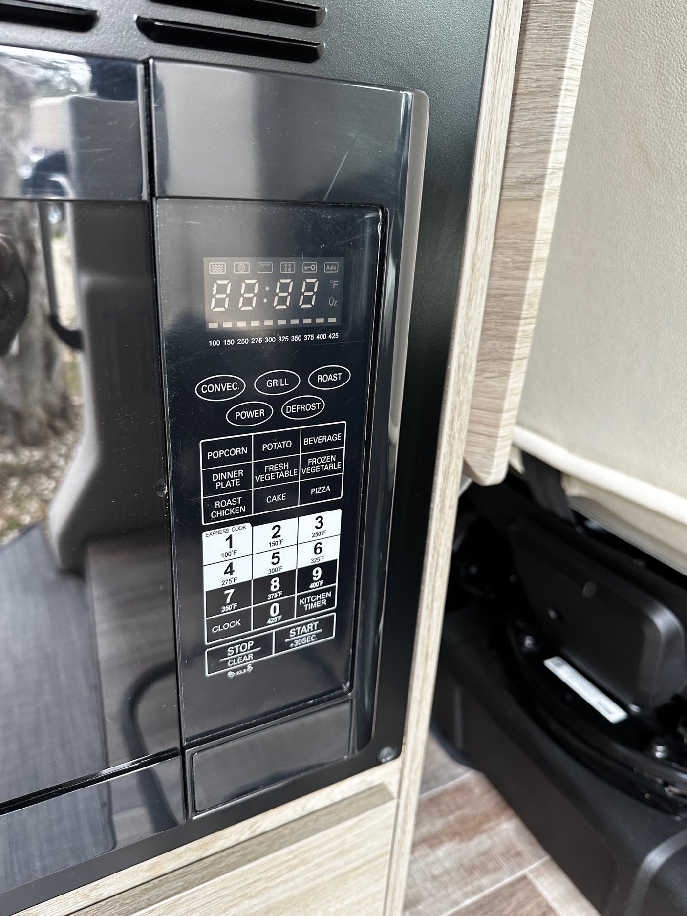 RV rental kitchen: Close-up of a microwave/convection oven control panel, showing functions and digital display.