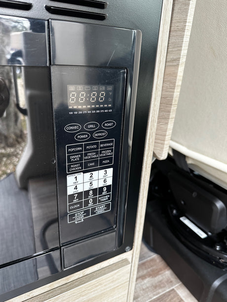 RV rental kitchen: Close-up of a microwave/convection oven control panel, showing functions and digital display.