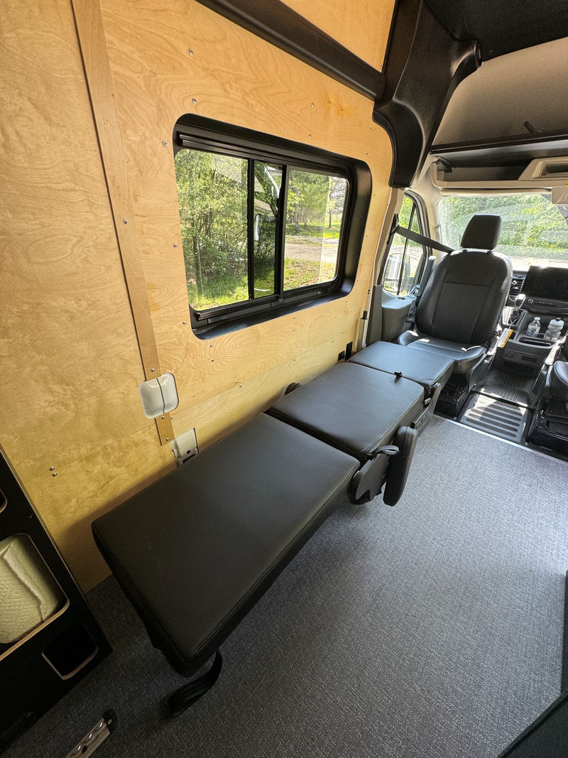  and induction cooktop. A bed is visible in the background.|Practical storage in an RV rental: A hand opens a wooden drawer in a compact kitchen with a cooktop & bed.|RV rental: Modern camper van kitchen with open fridge — photo 13