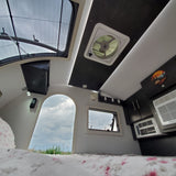 Inside a modern **rv rental**: a bright skylight, comfy bed, and built-in AC make for a great adventure space.