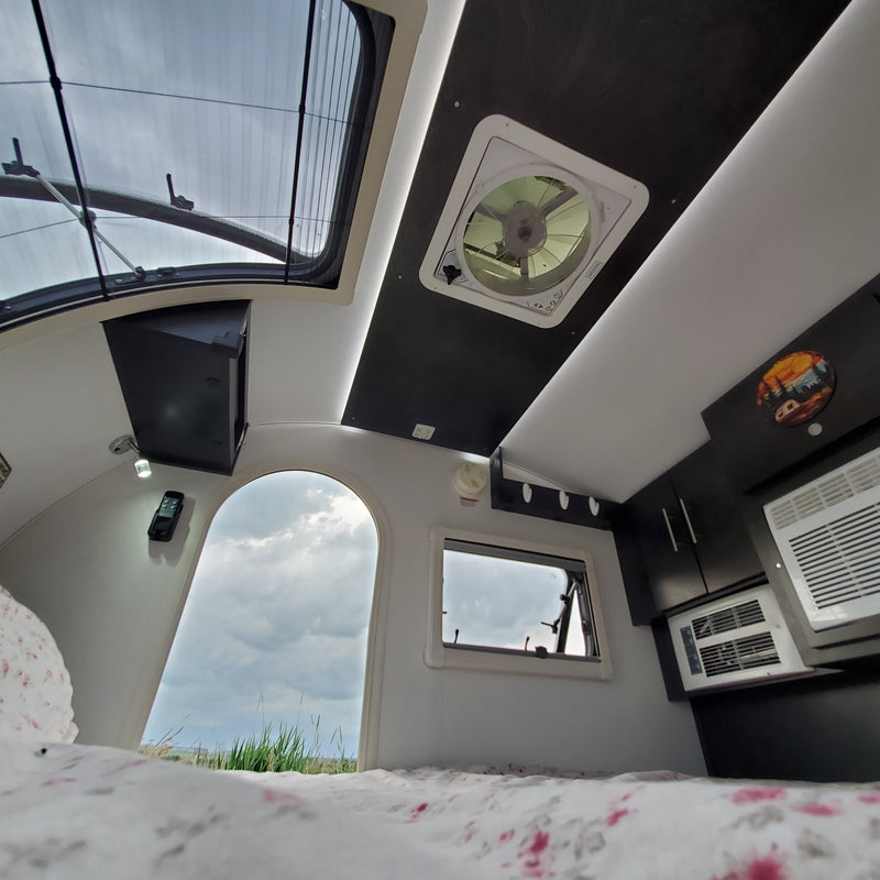Inside a modern **rv rental**: a bright skylight, comfy bed, and built-in AC make for a great adventure space. — photo 13