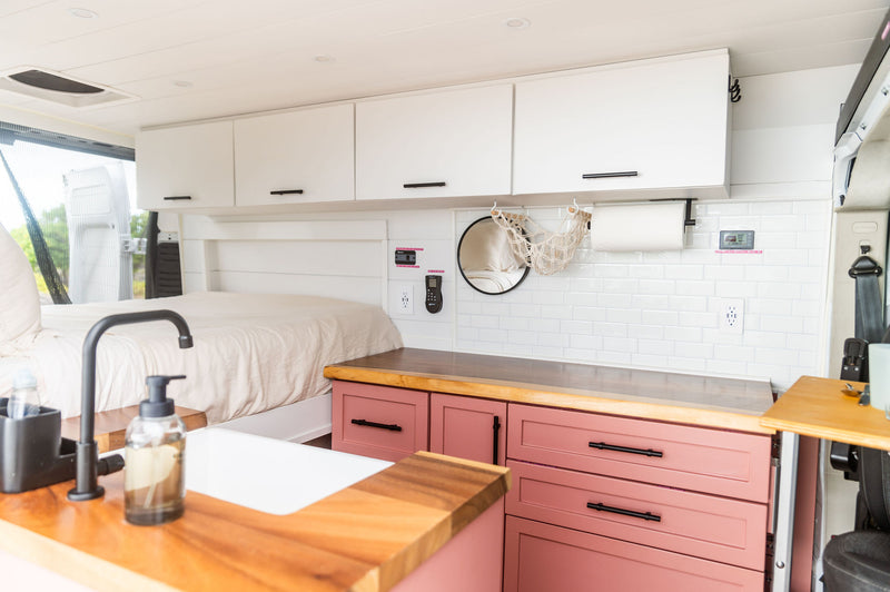 Bright & modern RV rental interior showcasing a cozy bed — photo 1