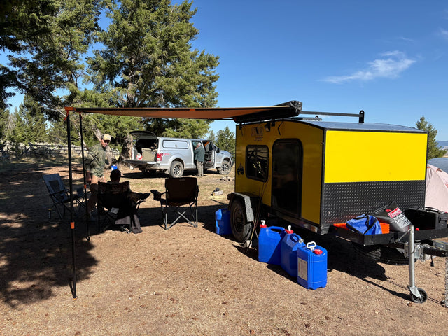 Sunny campsite with a bright yellow rv rental trailer