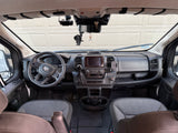 The spacious cockpit of an RV rental, showing the dashboard, steering wheel, and seats, ready for a journey.