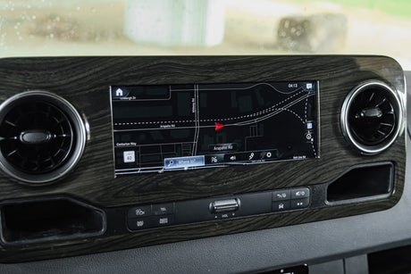RV rental dashboard: navigation map displays Arapaho Rd, with air vents & control buttons for media, phone, & volume.