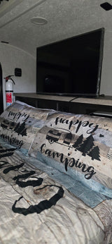 Cozy RV rental bedroom featuring "Happy Camping" bedding, a TV, and a fire extinguisher for safety. Perfect for your next adventure!