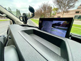 RV rental interior: Dashboard with a phone mount and a monitor displaying multi-camera views for easy navigation.