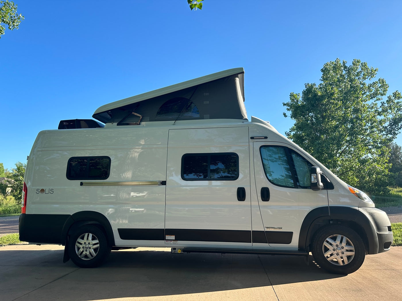 White camper van, pop-top deployed, parked under blue sky. Great for rv rental exploration! — photo 2