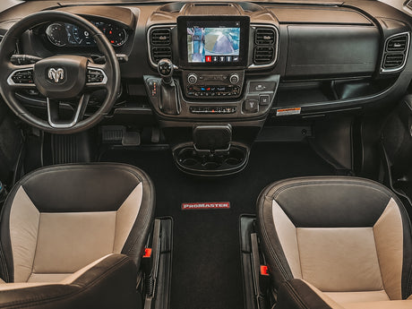 View of a Ram ProMaster RV rental interior, showing the cockpit, dashboard, infotainment screen, and two-tone front seats.