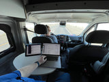 RV rental mobile office: Van life work setup with laptop & tablet while driving.