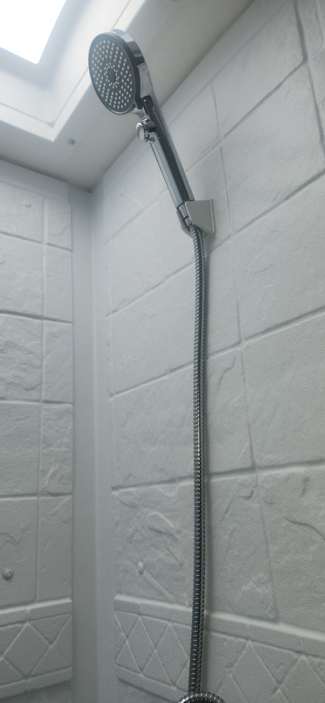 Compact shower in an RV rental, featuring a modern shower head, hose, and white textured walls.