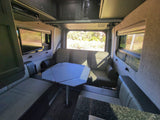 RV rental interior: versatile seating & dining area, entertainment system, and scenic windows for comfortable travel.