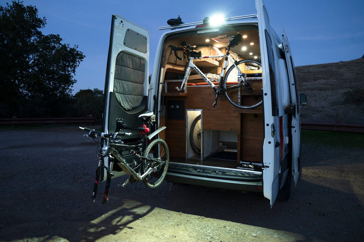  vast landscape and distant mountains under blue sky.|Adventure-ready rv rental: custom camper van interior with bikes mounted for travel — photo 4
