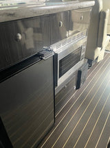 RV rental: Compact galley with refrigerator (note "PUSH TO OPEN" latch), microwave, and cabinetry.