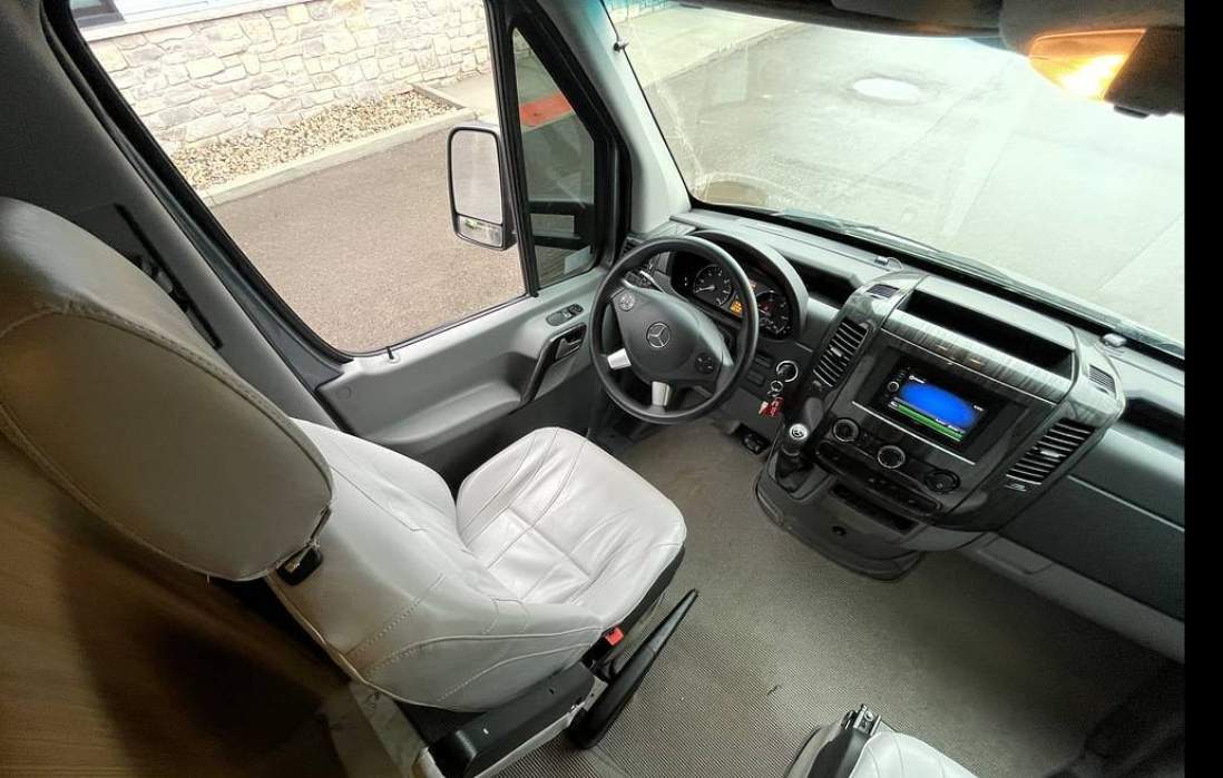  bathed in natural light.|Plush captain's chair in a spacious RV rental. Features light leather — photo 8