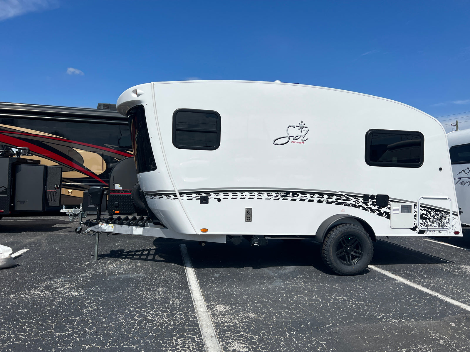 Compact Sol Rover travel trailer, ideal for your next RV rental adventure, parked on asphalt.
