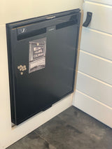 Built-in Dometic fridge in an RV rental, adorned with a Colorado magnet and others, offering compact storage.