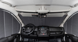 RV rental front cab interior with privacy shades deployed, showing the dashboard, steering wheel, and overhead console.