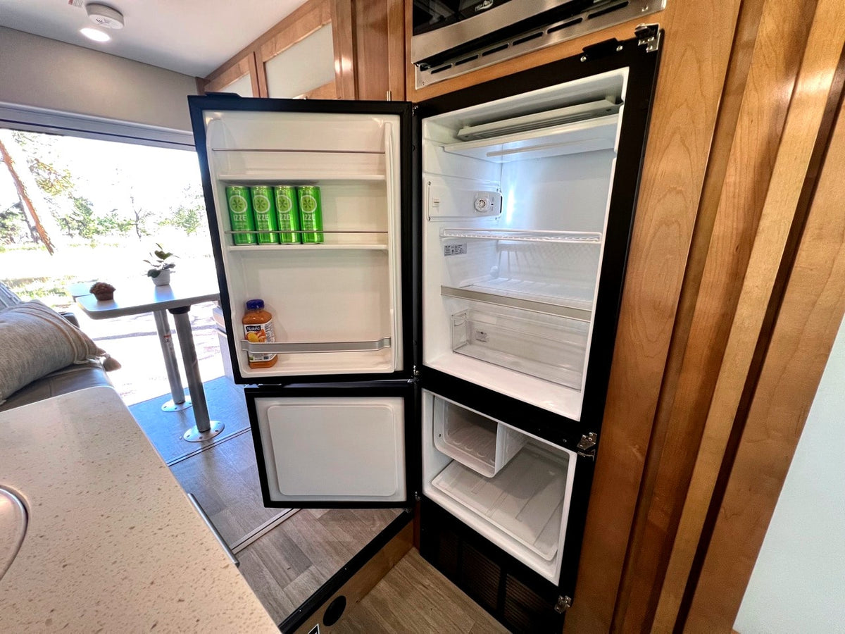 Inside an rv rental: an open RV refrigerator stocked with Izze drinks and juice, revealing shelves. — photo 14