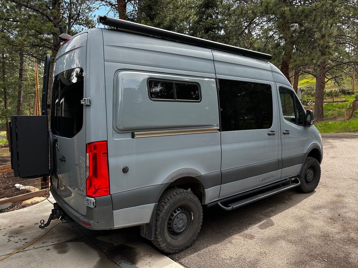 Gray Sprinter **rv rental** by VANSMITH. This adventure van features off-road tires, an awning, and rear storage. — photo 8