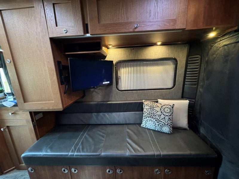  integrated into wooden cabinetry above a metallic counter. Shows user reflection.|This RV rental's open refrigerator shows a freezer — photo 15