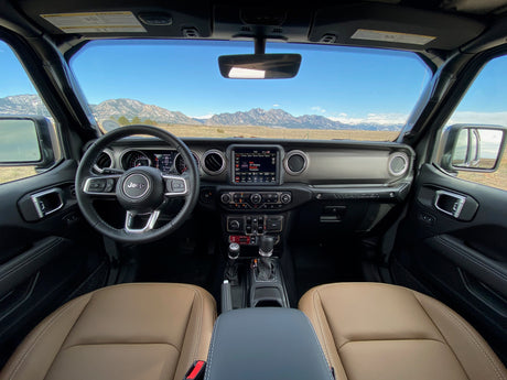 Jeep Wrangler interior with mountain vista, perfect for outdoor travel. More nimble than an rv rental for rugged terrain.