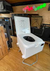 Portable Loo Seal toilet in an RV rental, with an Ecoflow unit, hexagonal lights, and wooden floor.