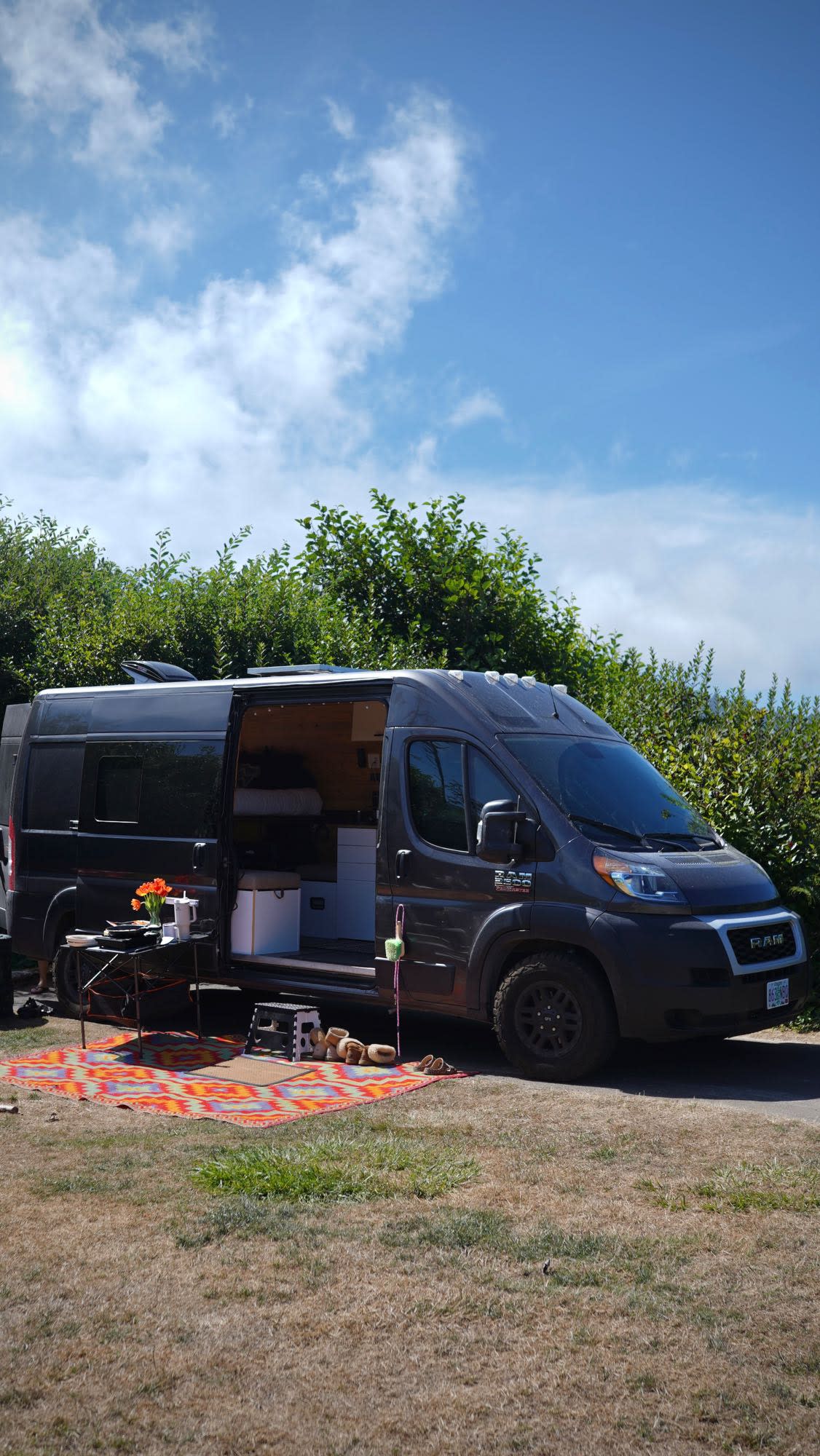  and kitchenette for adventure.|Back of an **RV rental** van open to show bed — photo 5