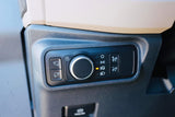 RV rental interior light controls: A dark gray dashboard panel with a rotary dial, showing headlights on, and various lighting buttons.