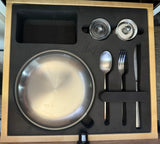 Compact and organized kitchen set with Snow Peak plate, cutlery, and shakers, ideal for your RV rental adventures.