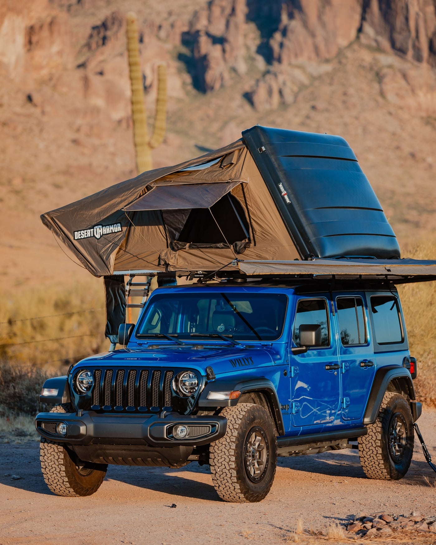 This blue Jeep Wrangler, equipped with a Desert Armor rooftop tent, offers an ideal RV rental for desert adventures. — photo 15