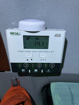 HQST 40A solar charge controller showing 14.1V, managing solar power to batteries and DC loads in this RV rental setup.