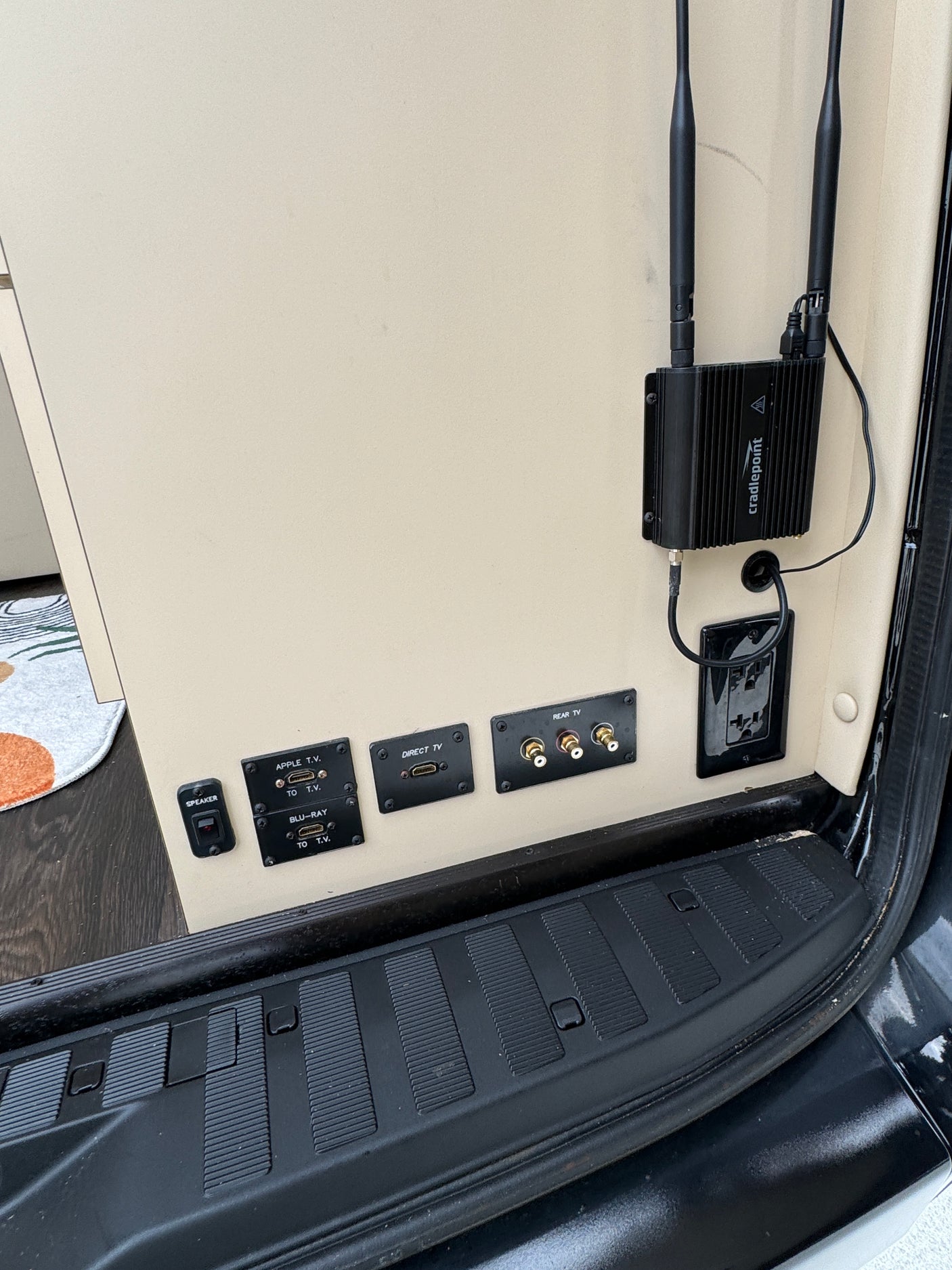 Inside an RV rental: entertainment/connectivity hub with Cradlepoint router, HDMI inputs (Apple TV, Blu-ray, Direct TV).