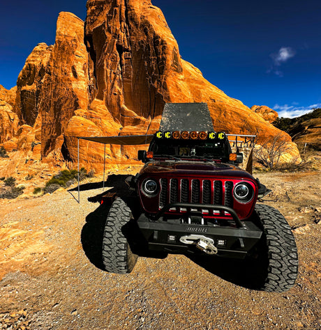 This rugged Jeep off-road vehicle with an awning is perfect for desert adventures. Explore red rock formations with an rv rental!