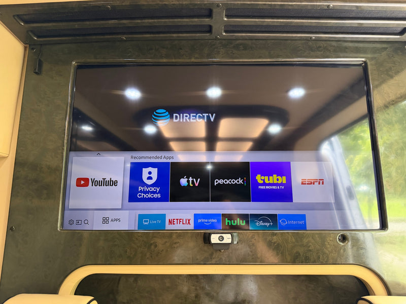 Inside an **rv rental**, a smart TV displays DIRECTV and popular streaming apps like Netflix and Hulu, with a webcam below, for entertainment. — photo 14