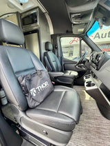 Spacious rv rental van interior featuring front captain seats, a Thor bag, built-in microwave, and fridge.