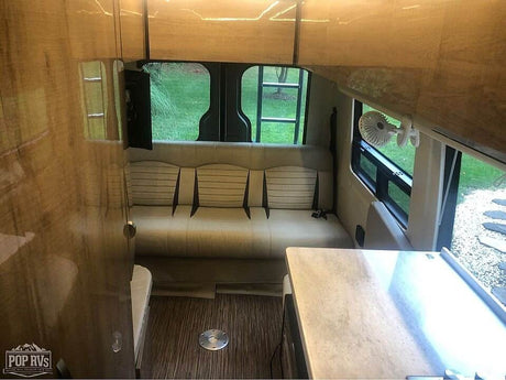  is parked outdoors on a sunny day.|Luxury Era camper van for your next RV rental adventure. See the spacious interior and open side door.|RV rental interior layout: Sofa/bed