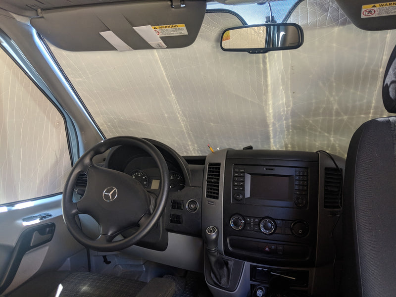 Mercedes-Benz van interior, possibly an RV rental, with dashboard, steering wheel, and sunshade providing privacy. — photo 10