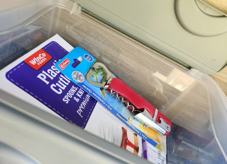 RV rental travel essentials: Plastic cutlery and a 3-in-1 corkscrew/opener neatly stored in a clear bin.