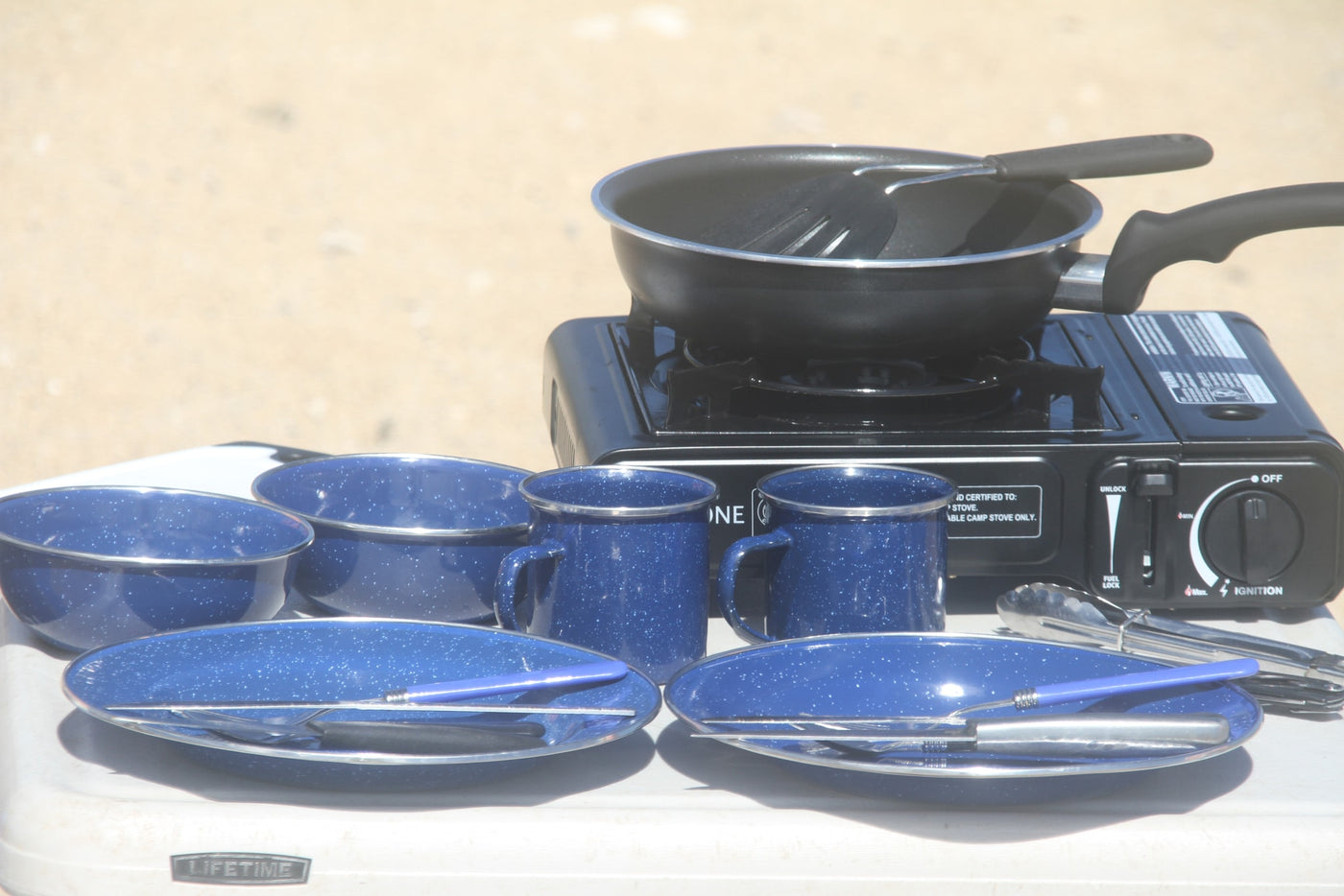 RV rental ready: Portable camp stove with a pan, blue enamel dishes, and utensils for outdoor meals. — photo 10
