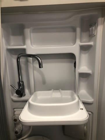 This RV rental's space-saving wet bath features a fold-down sink, versatile faucet, and built-in storage. — photo 16