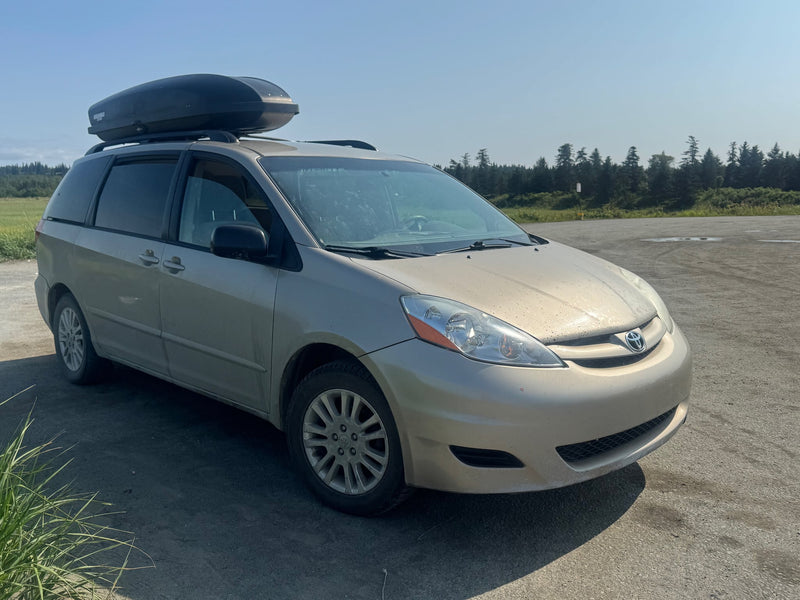  parked by the ocean. Roof rack has a large cargo box.|Minivan with a DIY bed platform for an RV rental adventure — photo 10