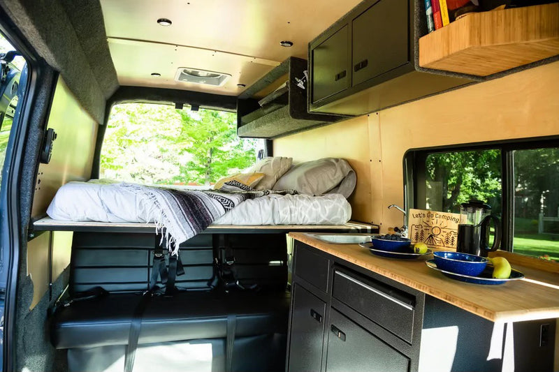  enjoying nature.|Experience nature with an RV rental! A woman and girl exit their camper van in a beautiful mountain park setting.|This cozy RV rental interior features a comfy bed — photo 5