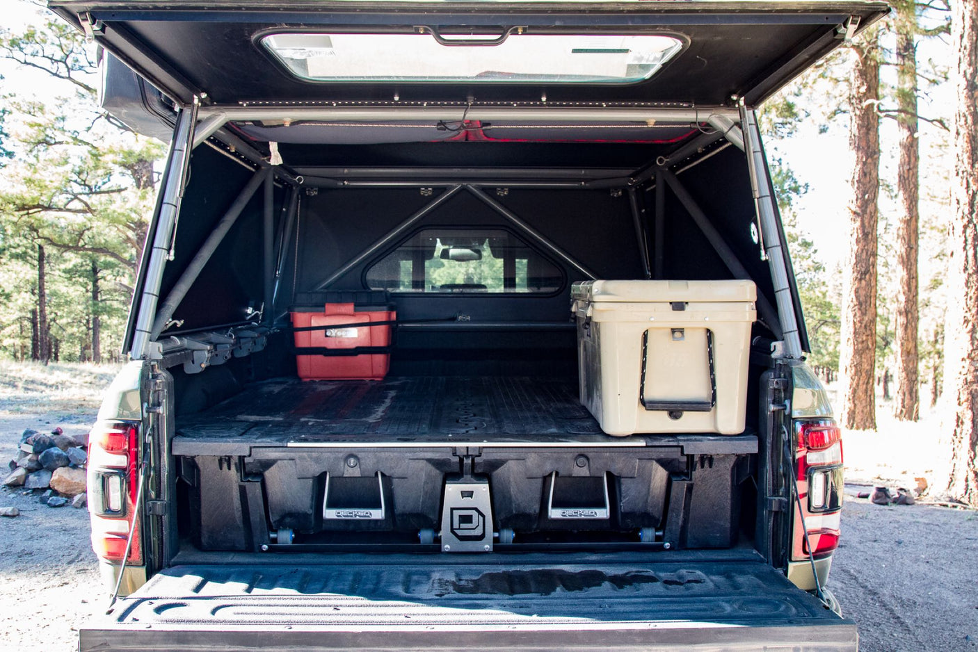 An organized truck bed with a drawer system, cooler, and camper shell offers ideal storage for an RV rental trip.