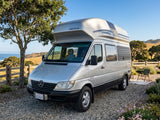 Silver Mercedes Westfalia RV rental parked overlooking a scenic California coast, ready for adventure.