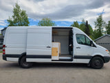 White Mercedes-Benz Sprinter camper van with open side door revealing a cozy, custom interior. Ideal for RV rental adventures.