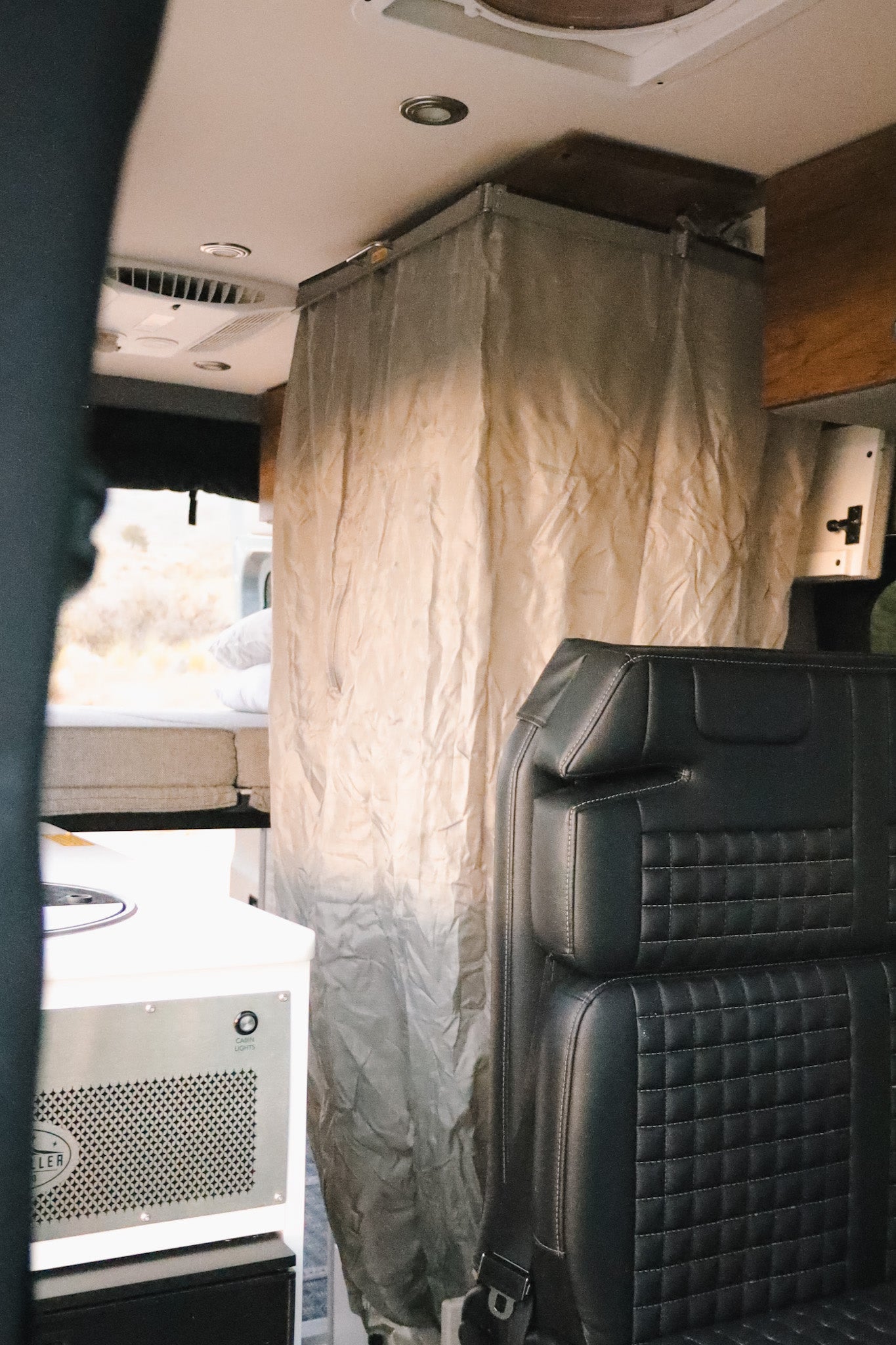 This rv rental offers a compact shower, quilted seat, and convertible bed, creating a functional travel space.