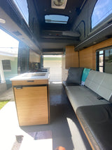 This RV rental offers a spacious interior with a full kitchenette, sofa, and pop-top bed, perfect for mobile living.
