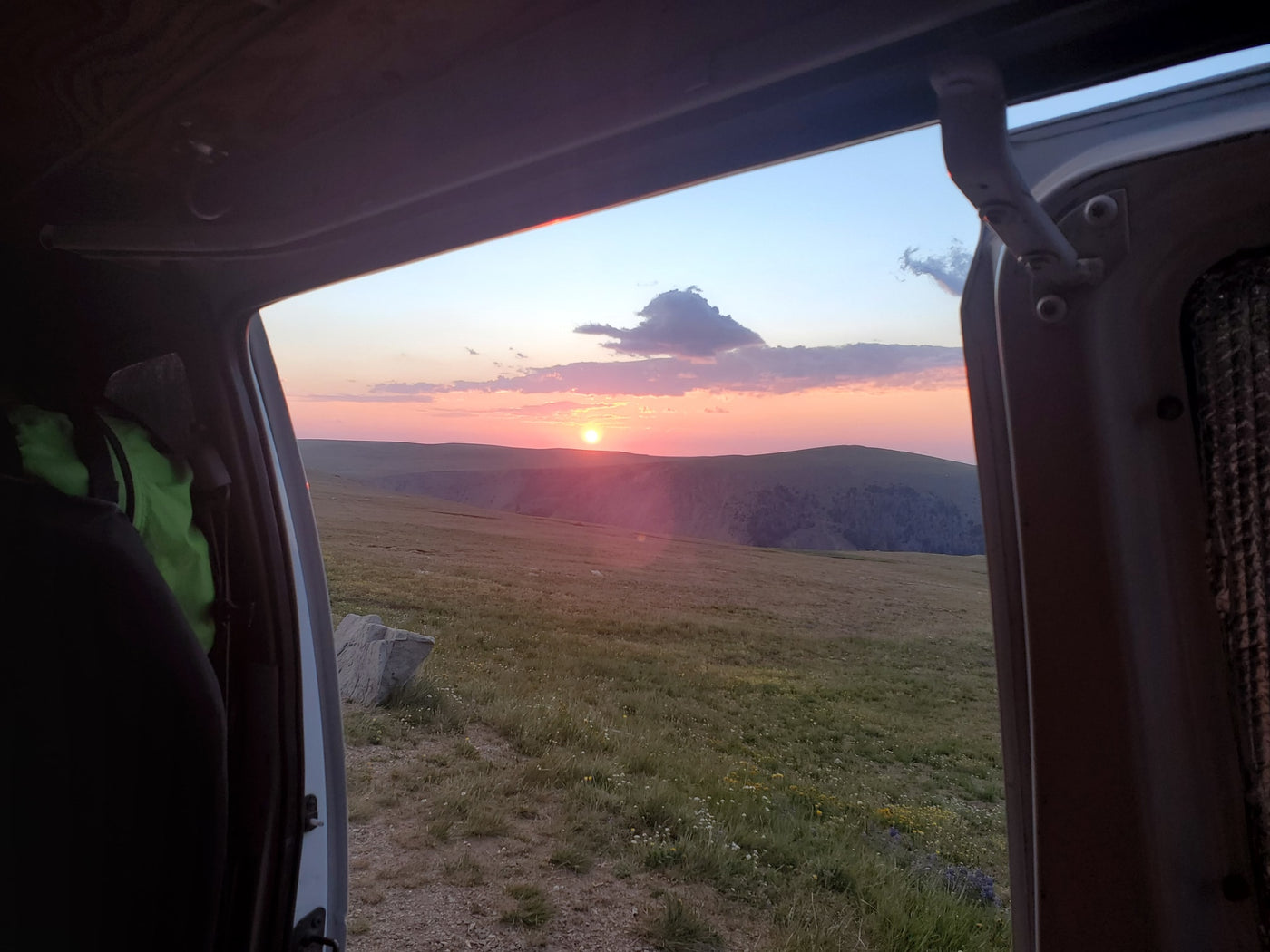  and portable fridge for adventure travel.|This RV rental offers a compact camper van interior with a bed — photo 12