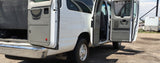 This white RV rental van has its rear and side doors open, revealing its cargo area and interior.